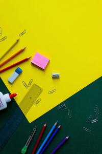 Various school supplies on a yellow piece of paper.